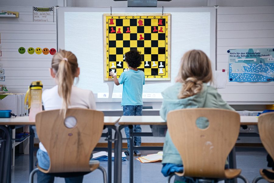 Grundschulklasse am Demonstrationsbrett, Kinder von hinten